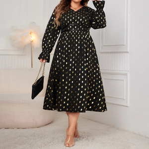 Detailed view of long sleeve V-neck dress featuring gold polka dot print and pleated cuffs