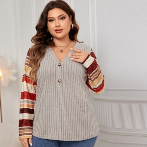 Detail of grey V-neck top with colorful striped sleeves and rustic wooden buttons