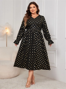 Detail of V-neckline and golden polka dot print on black high waist midi dress