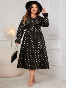 Detail of V-neck maxi dress featuring golden polka dots on black fabric with flared cuffs