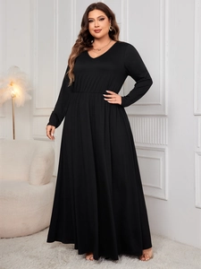 Detail of high-waisted plus size black maxi dress with long sleeves and elegant V-neckline