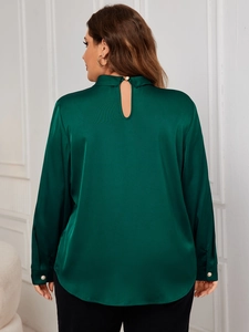 Detail of dark green satin shirt back featuring pearl button closure and silky texture