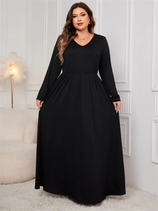 Detail of the high-waisted cut and flowy A-line skirt of this plus size black V-neck dress
