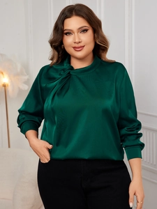 Detailed close-up of dark green satin shirt with elegant twist neckline and silky finish