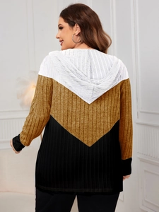 Macro view of knit hooded cardigan back showing vertical stripe texture and tri-color V-pattern