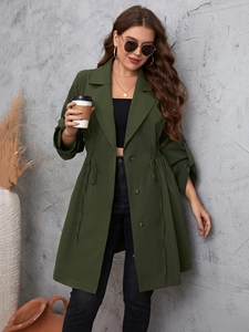 Dettaglio di un trench verde oliva con rever classico e coulisse regolabile in vita per donna