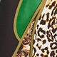 Detailed view of leopard print dress fabric with green patches and gold stitched outlines