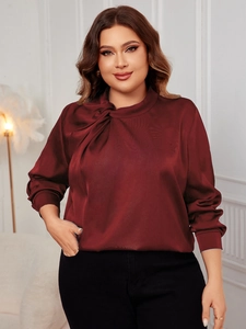 Detail of burgundy satin blouse with pleated knot neckline and smooth glossy fabric