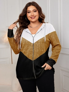 Detail of ribbed knit color-block jacket showing V-shaped stripes and zipper closure