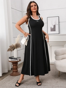 Détail de la robe longue noire moulante avec bordures blanches et broderie California