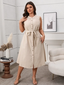 Detail of beige sleeveless dress featuring wooden buttons and a matching waist tie belt