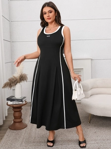 Détail de la robe noire sans manches avec passepoil blanc contrasté et texture de jupe plissée