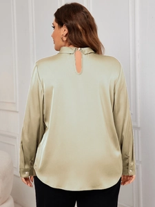 Detail of champagne satin blouse featuring keyhole back and elegant pearl buttons