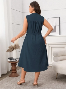 Detail view of the back of a navy sleeveless midi dress with waist tie and pleated yoke