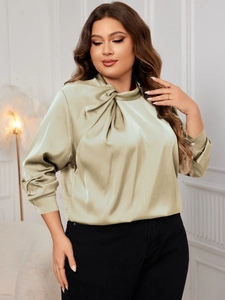 Detail of elegant satin long sleeve blouse featuring a knotted high neckline in sage green