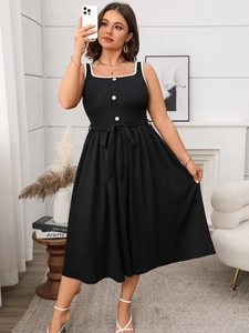 Detail of elegant black dress with contrast white binding, square neck and chic buttons
