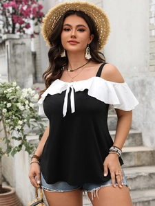 Detail of off-shoulder neckline with white ruffle trim and bow tie on black top