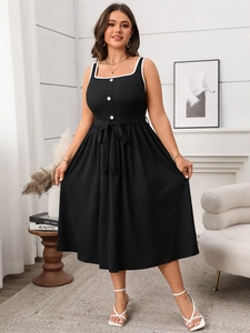 Detail of black A-line dress with square neckline, white piping and contrast buttons