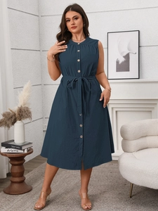Detail view of navy blue sleeveless dress featuring button-front and belted waist