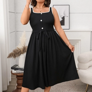 Detail of black sleeveless A-line maxi dress with white contrast trim and button accents