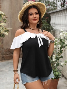 Detail of off-shoulder top featuring white ruffle trim and a delicate bow tie detail