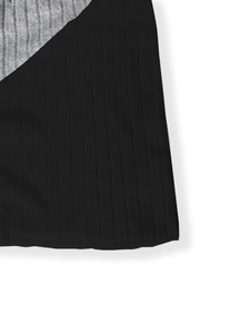 Detailed macro shot of grey and black ribbed knit fabric patchwork on cardigan hem