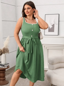 Detail of green sleeveless dress with lace-trimmed square neck and waffle texture fabric