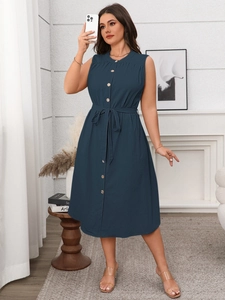 Detailed view of dark blue button-down sleeveless dress with waist tie and fabric texture