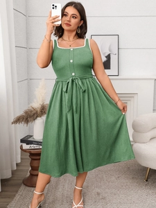Detail of square neckline with white scalloped lace trim on green sleeveless dress