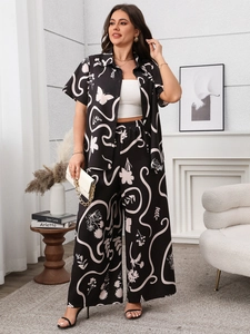 Detail of a black two-piece set featuring abstract floral prints and wide-leg trousers
