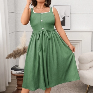 Detail of green summer dress featuring square neckline with white lace and button accents