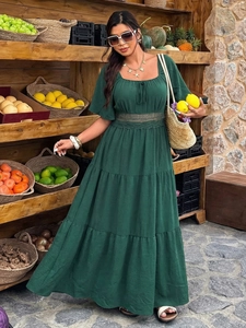 Détails de robe bohème verte à volants avec col carré et dentelle au marché de rue