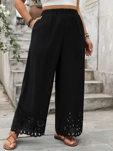 Detailed view of the laser-cut hollow pattern on the black wide-leg trousers' hem