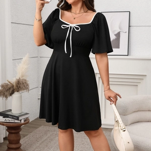 Detail of square neckline with white contrast piping and elegant bow on black plus size dress