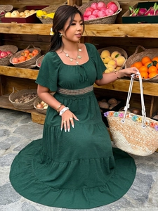 Gros plan détaillé sur la robe longue vert foncé avec dentelle crochetée et jupe à volants