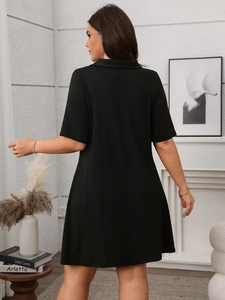 Rear view of black short sleeve polo dress showing its elegant A-line silhouette and drape