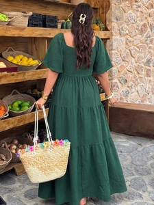 Détail de robe longue verte foncée à volants avec tissu texturé et décolleté carré rétro