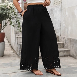 Women's black high waisted wide leg pants with hollow-out floral lace hem detail
