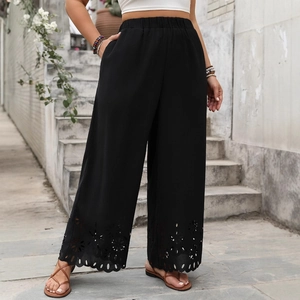 Women's black wide-leg pants with elastic waist and hollow-out floral lace hem detail