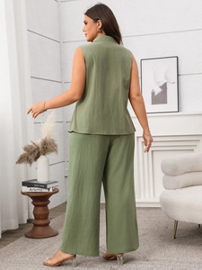 Detail of sage green two-piece set featuring long sleeveless vest and wide-leg trousers