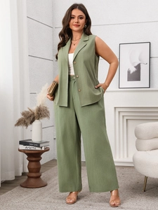 Detail view of women's sleeveless green vest and wide-leg pants in a cozy indoor setting