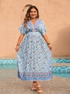 Detail of bohemian floral print on a blue V-neck maxi dress with paisley border design