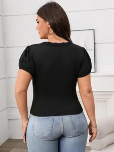 Close-up of women's slim fit black knit T-shirt featuring lace neckline and puff sleeves