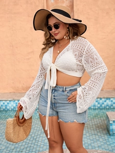 Detail of white hollow crochet knit cover-up with bell sleeves and front tie closure