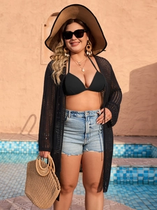 Detail view of black long hollow knit cardigan paired with bikini and denim shorts