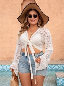 Detailed view of white crochet lace top with deep V-neck and front tie-up closure detail