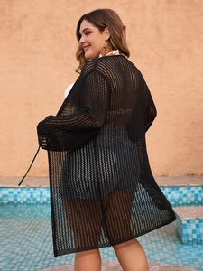Detail of black crochet knit cover-up showing mesh texture against a pool background
