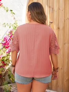 Detail view of brick red top featuring crochet lace sleeves and vertical striped texture