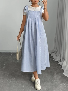 Detail of blue striped pinafore dress with bow shoulder straps and side pockets