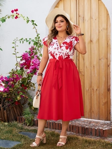 Detail of red floral patchwork dress with a V-neck and decorative waist bow tie